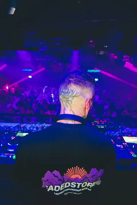 DJ at the decks over a purple-lit floor, event photography by Party Pixel