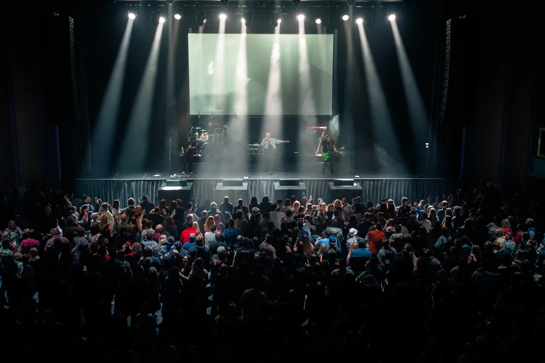Full venue under white beams at a live show, event photography by Party Pixel