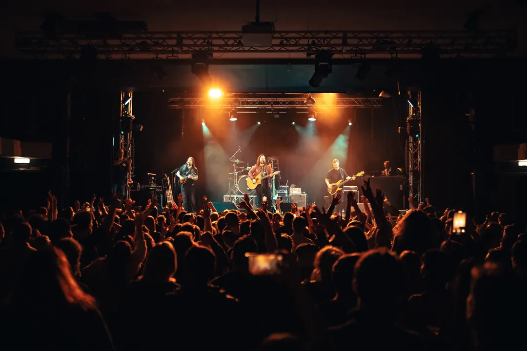 Band on stage in front of the crowd, event photography by Party Pixel